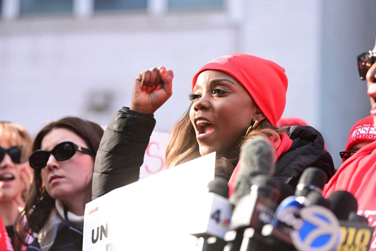 woman wearing red holding a sign