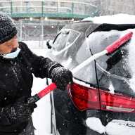 WINTER STORM WARNING: NYC expected to get 6-12 inches of snow. Here's what you need to know. 8 winter storm man clears snow off windshield of car