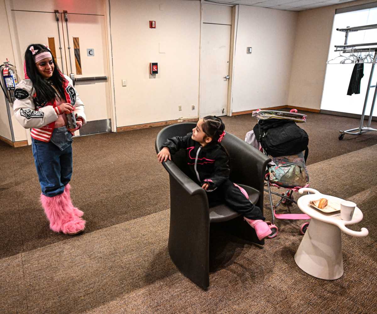 woman in a room with her daughter, who is sitting in a chair 