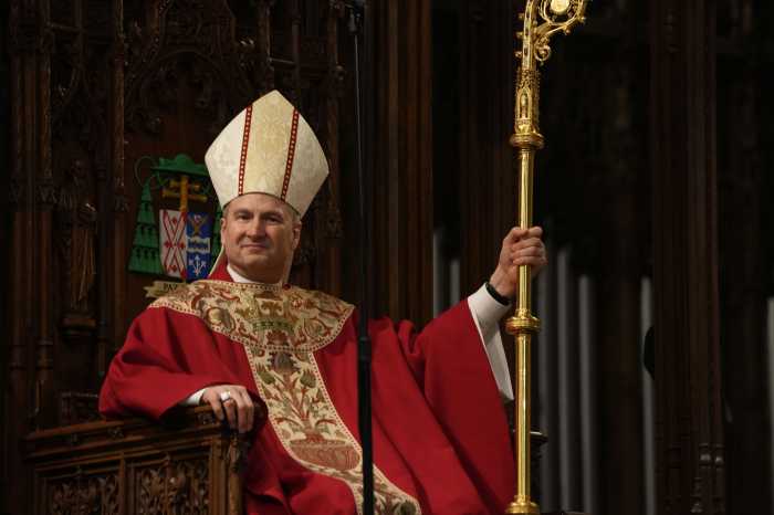 Archbishop Ronald Hicks sitting on altar with crozier