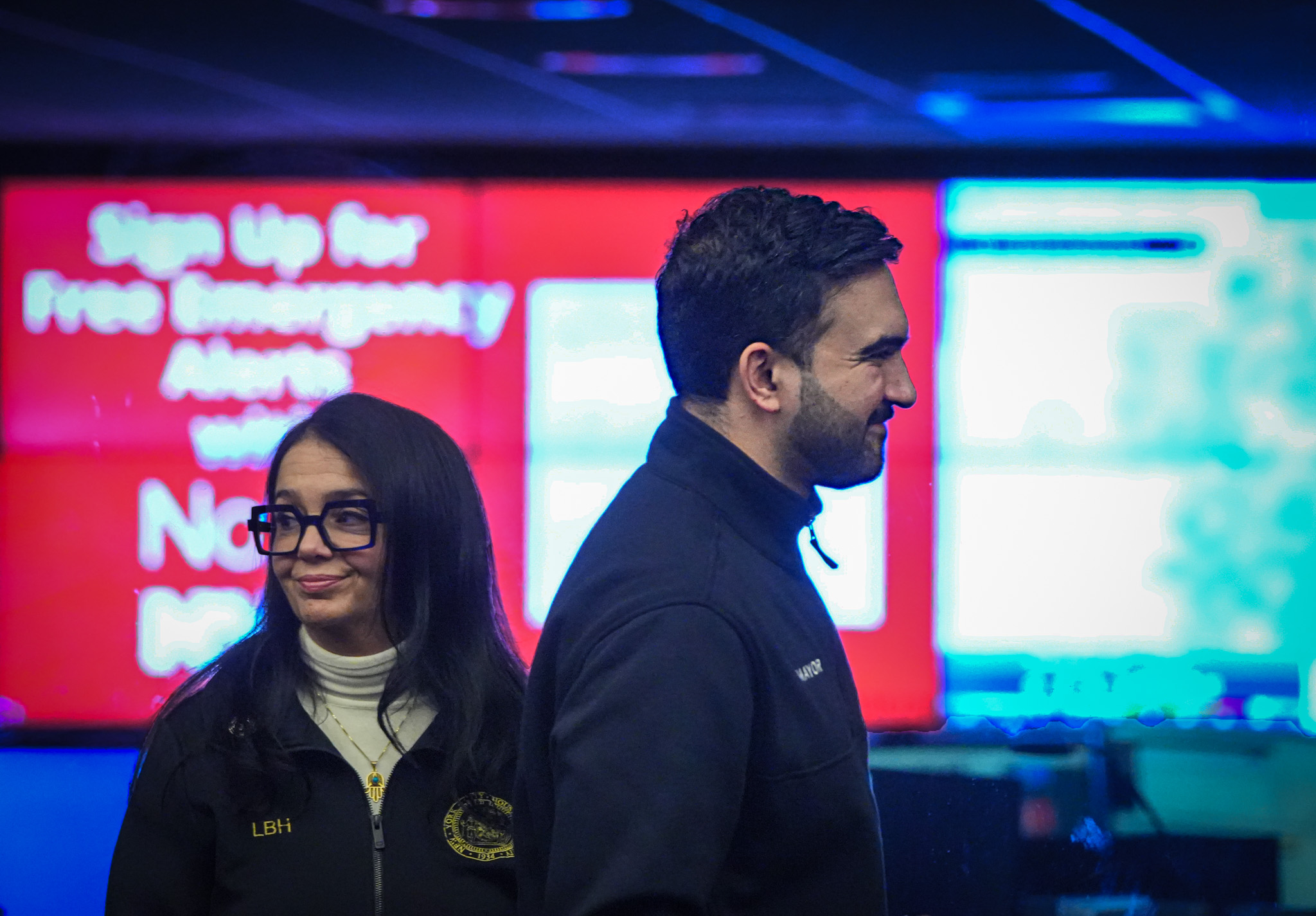 two people standing in front of a screen