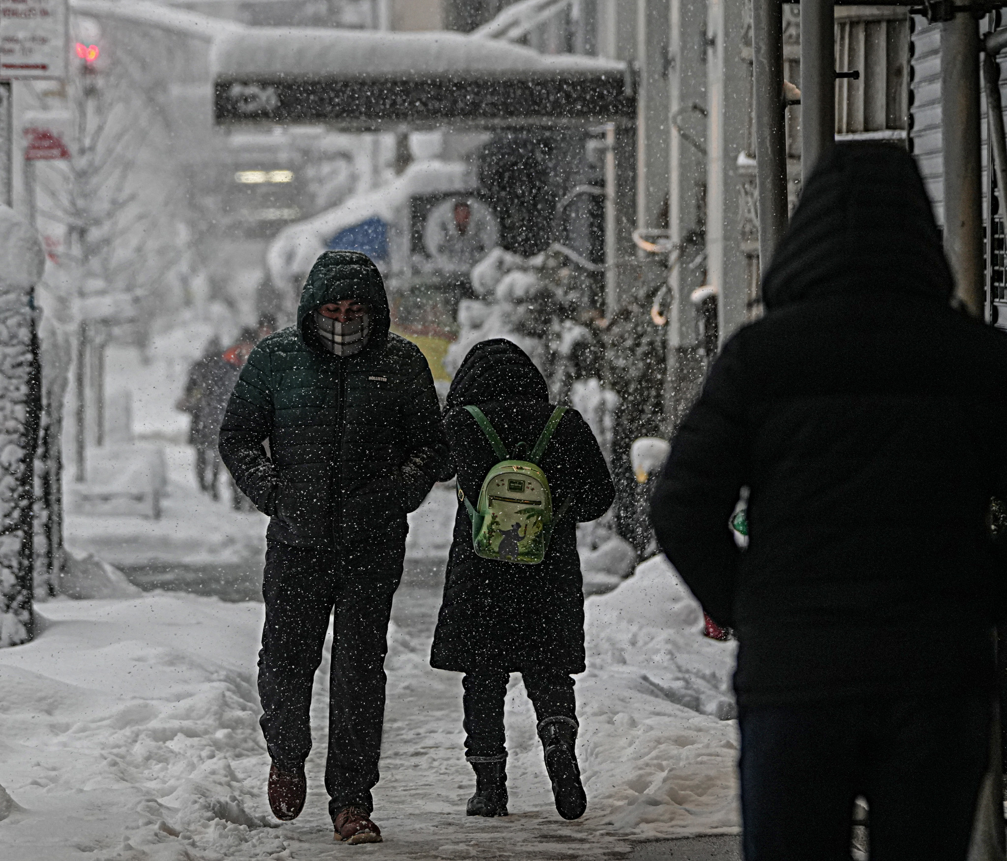 people walking on a snowy day on a sidewalk