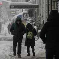 NYC BLIZZARD: Public schools will open for in-person classes on Tuesday 6 people walking on a snowy day on a sidewalk