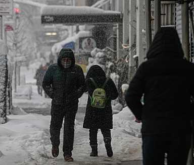 people walking on a snowy day on a sidewalk
