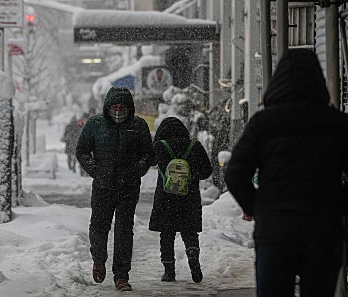 people walking on a snowy day on a sidewalk