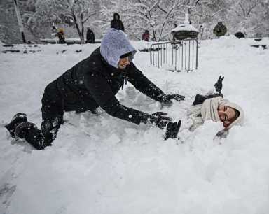 people playing in snow after nyc blizzard