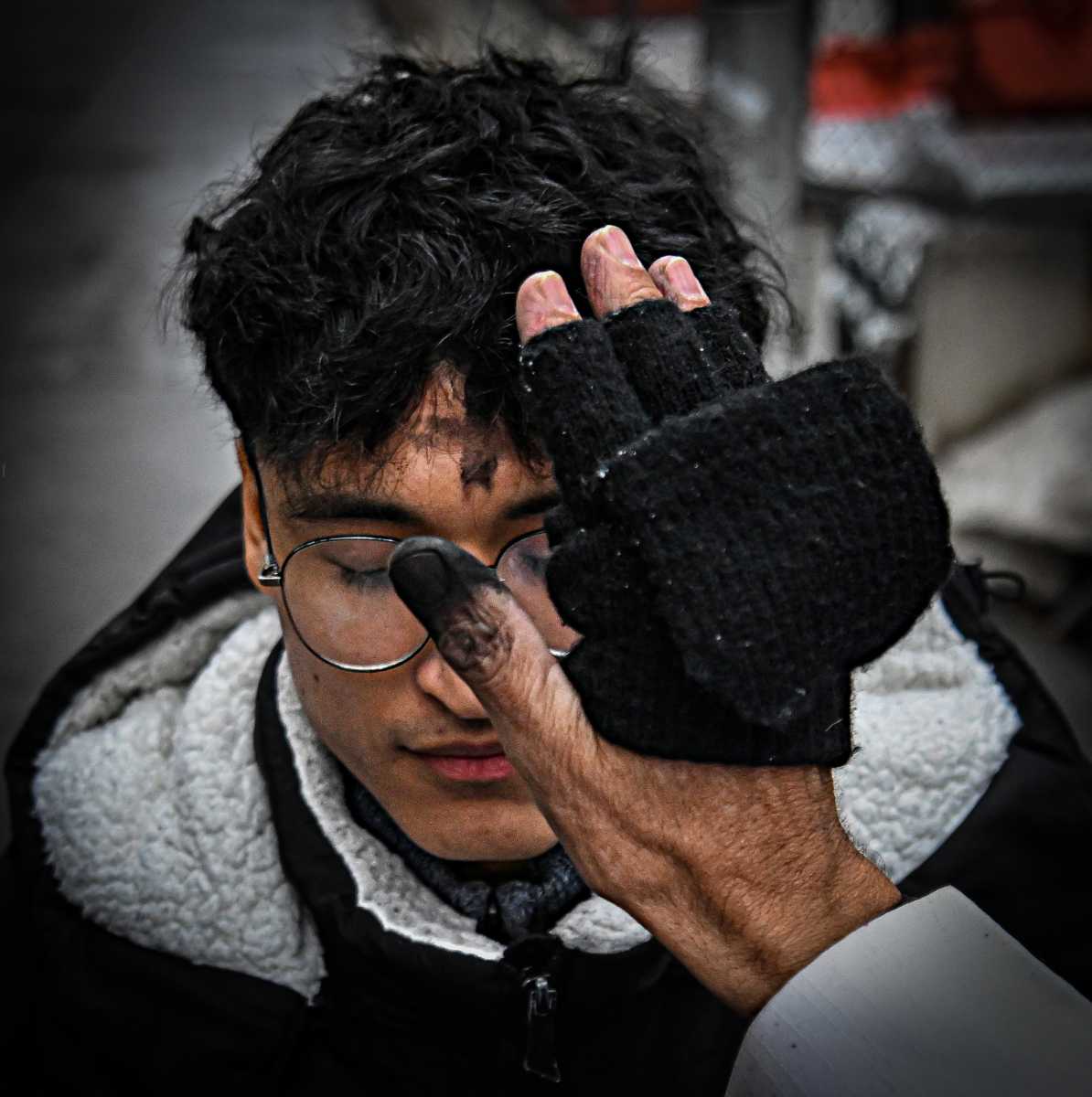 Priest administers ashes on Ash Wednesday to immigrant at Federal Plaza