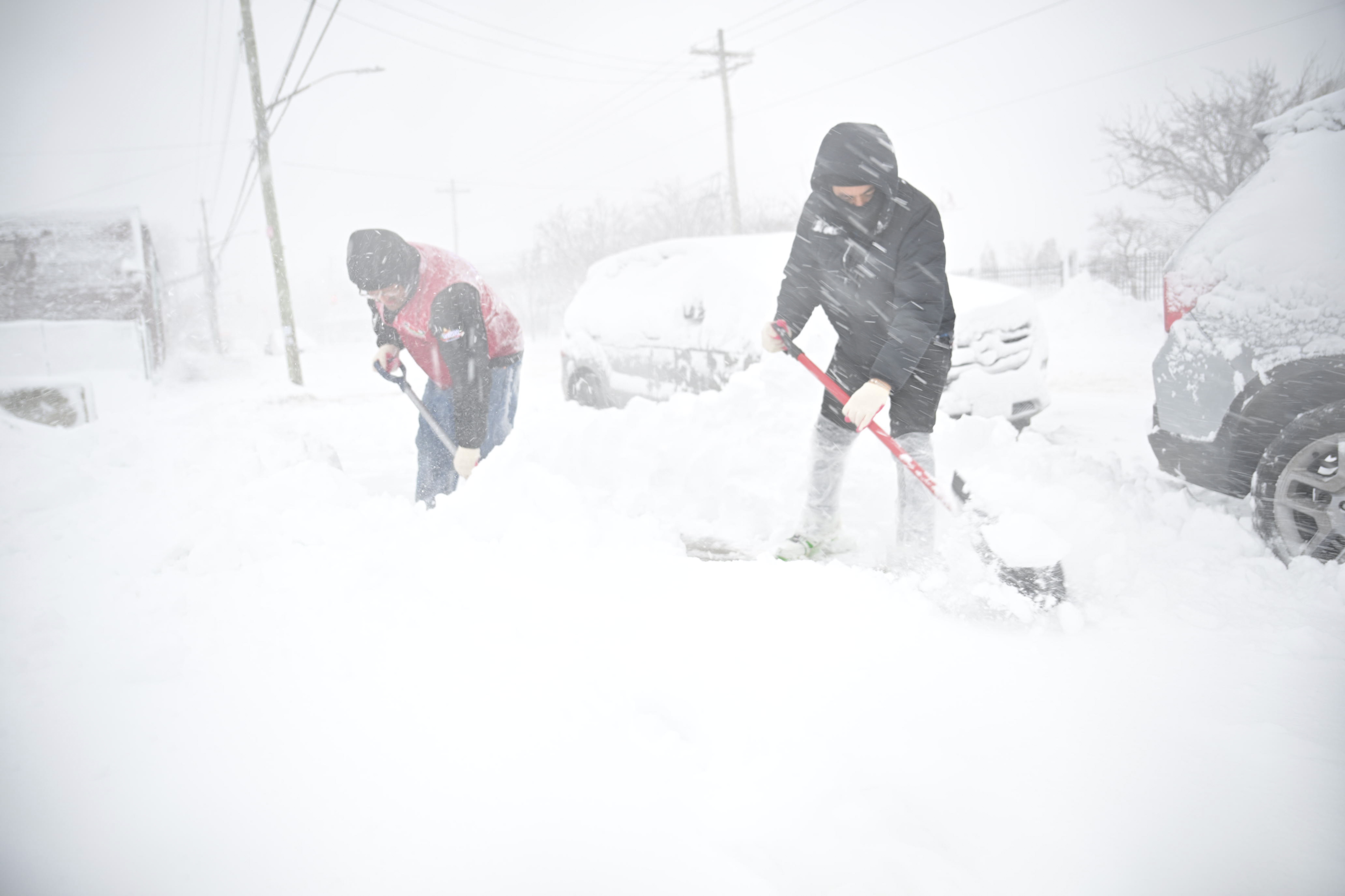 people shoveling sidewalks in Brooklyn during NYC blizzard