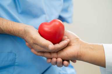 Asian doctor give red heart to elderly woman in her hand, heart Attack.