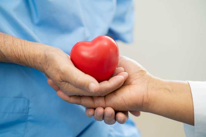 Asian doctor give red heart to elderly woman in her hand, heart Attack.