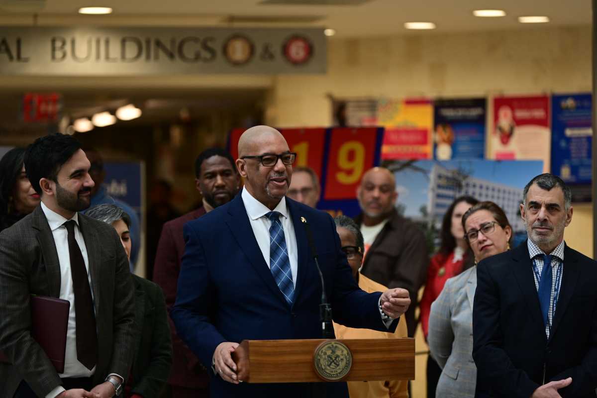 two men, including Mayor Mamdani, wearing suits at a podium