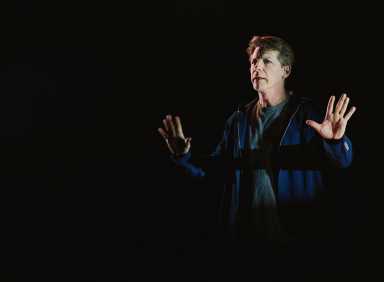 an actor who looks serious performing on stage