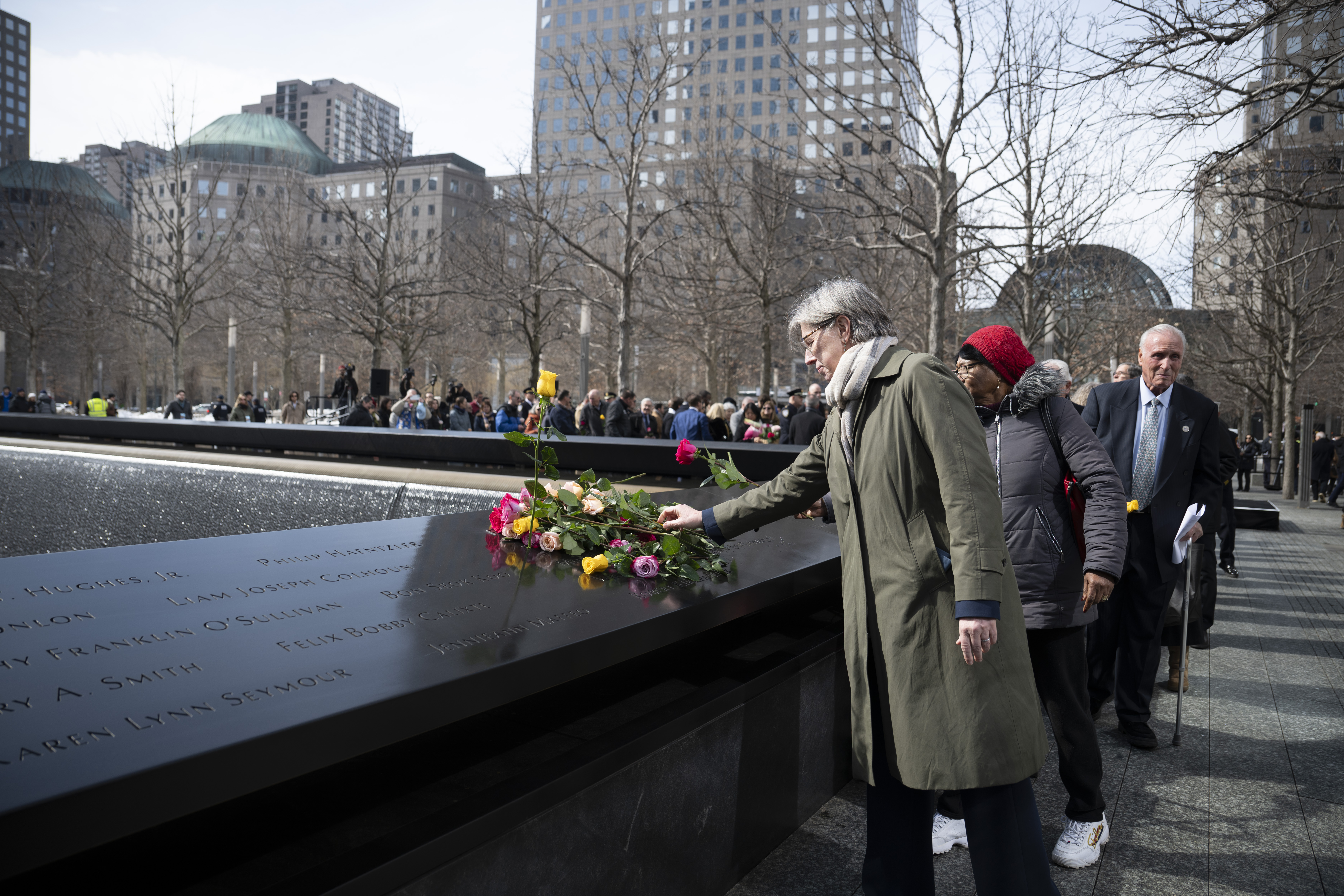 family members place flowers at 9/11 memorial during ceremony for 1993 World Trade Center bombing victims