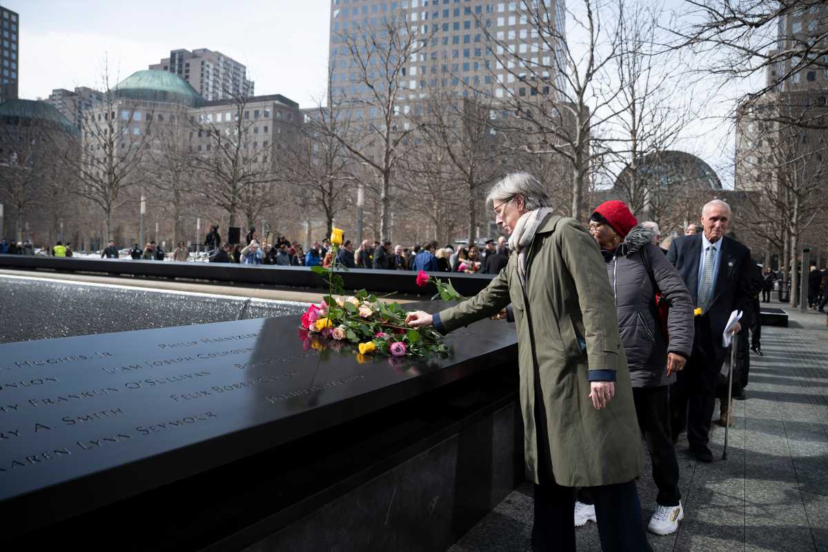 family members place flowers at 9/11 memorial during ceremony for 1993 World Trade Center bombing victims