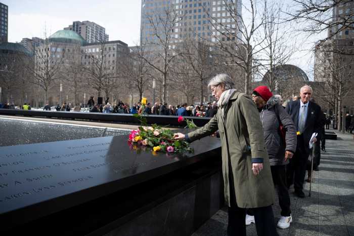 family members place flowers at 9/11 memorial during ceremony for 1993 World Trade Center bombing victims