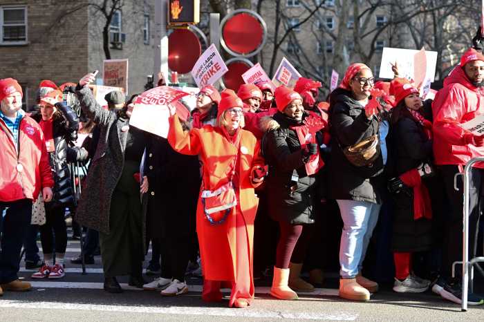 group of people holding signs in a street during a nurses strike