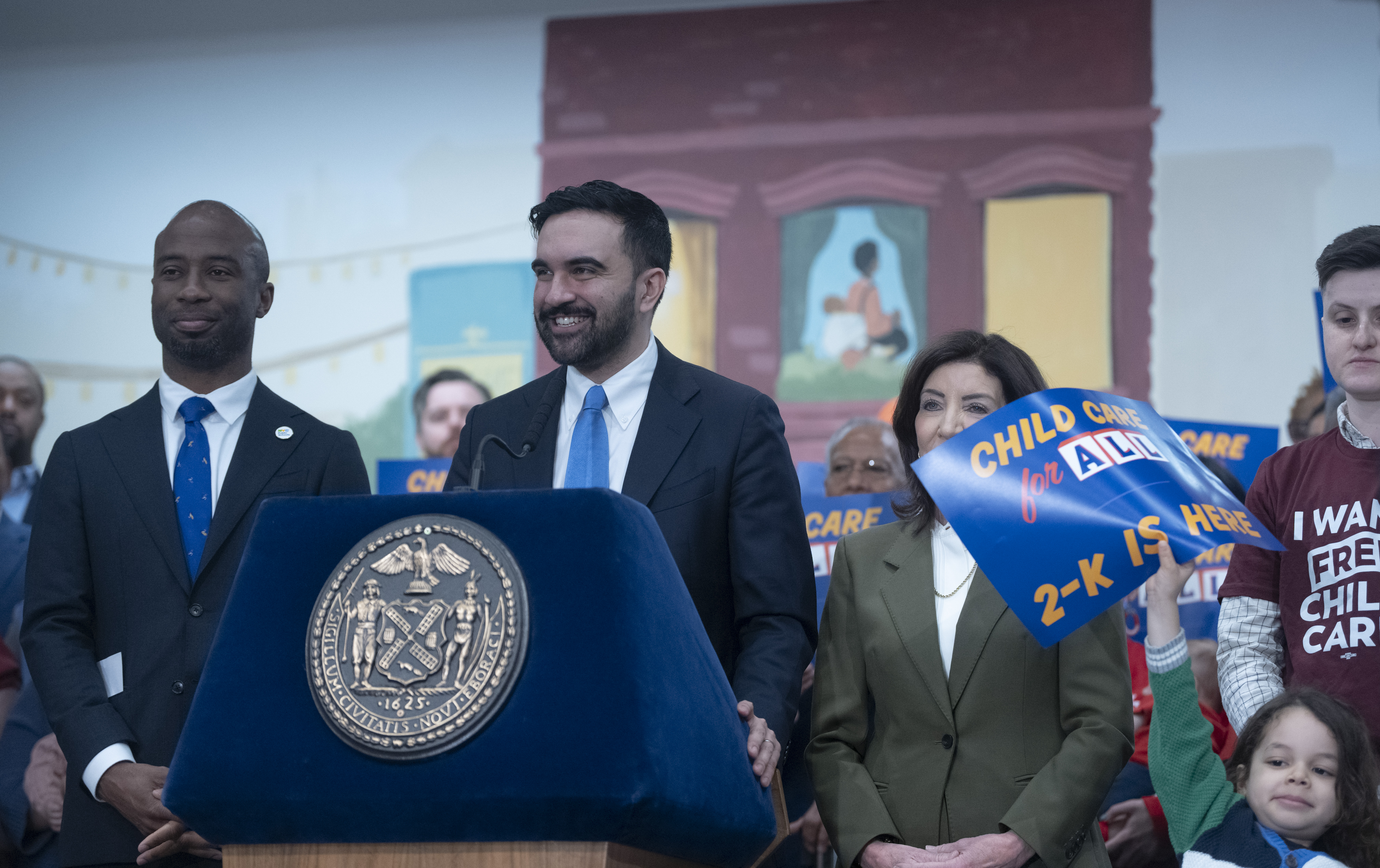Mamdani smiling at podium at childcare announcement